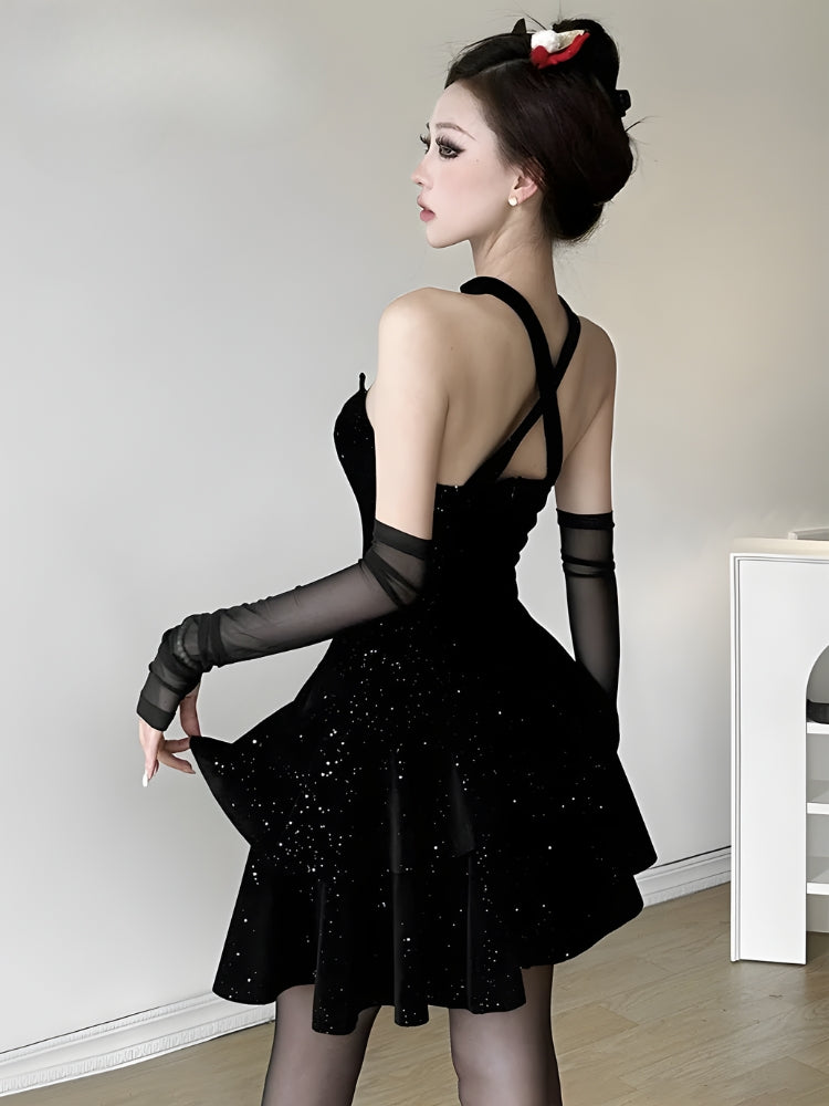 Back view of a woman in a black sequined dress with a halter neckline and sheer opera gloves.