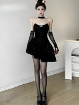Full length shot of a woman in a black sequined strapless dress, black tights, and black heeled shoes, with sheer opera gloves.