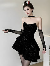 Woman wearing a black sequined strapless dress with sheer black opera gloves and a choker necklace.