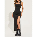 woman posing in a black cutout maxi dress with a high slit