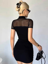 A woman in a black ruched mesh top dress with a mock neck and short sleeves, shown from the back.