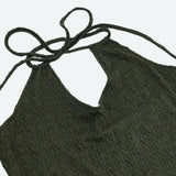 Close-up of the halter neck and keyhole cutout of an olive green dress