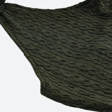 Close-up of the textured fabric and hem of an olive green dress