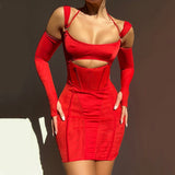 A woman wearing a tight, short red dress with a cutout at the bust and long, detached sleeves. The dress has a corset-like bodice and thin straps.
