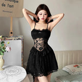 Woman wearing a black lace slip dress, hands on head
