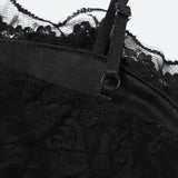 Close-up of the spaghetti strap and lace detail on a black slip dress