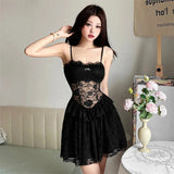 Woman wearing a black lace slip dress, front view