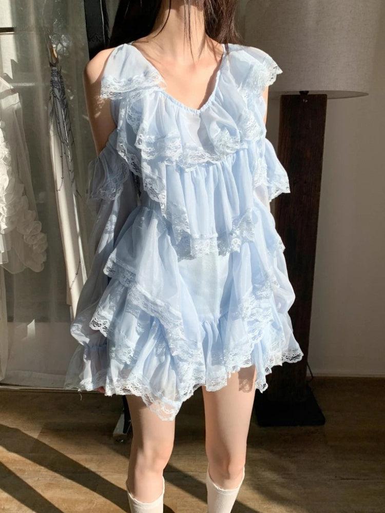 A young woman is shown from the chest down in a light blue, ruffled, off-the-shoulder dress with lace trim.