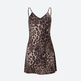 A short leopard print slip dress with spaghetti straps, laid flat.