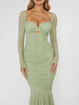 Close-up of a woman's torso in a green ruched midi dress with a cutout detail