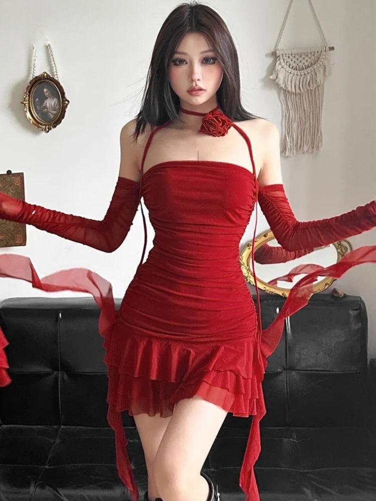 A woman wearing a red ruched mini dress with sheer sleeves and ruffles