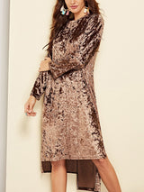 Side view of a woman in a crushed velvet brown dress, showcasing the texture and the flow of the fabric.