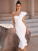 A close-up of a woman in a white one-shoulder dress with a ruffled accent, showing the dress's fit.