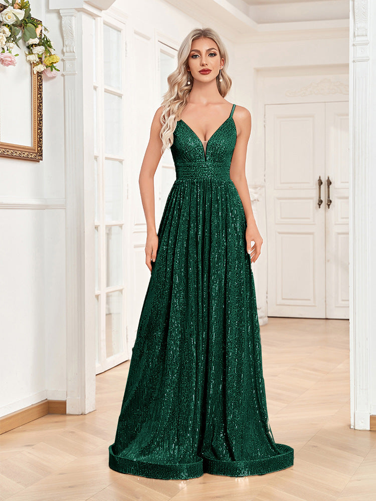 Woman in an emerald green sequined floor-length dress with spaghetti straps and a v-neck