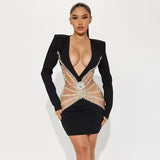 Woman wearing a black mini dress with a plunging neckline and sheer, embellished midsection.