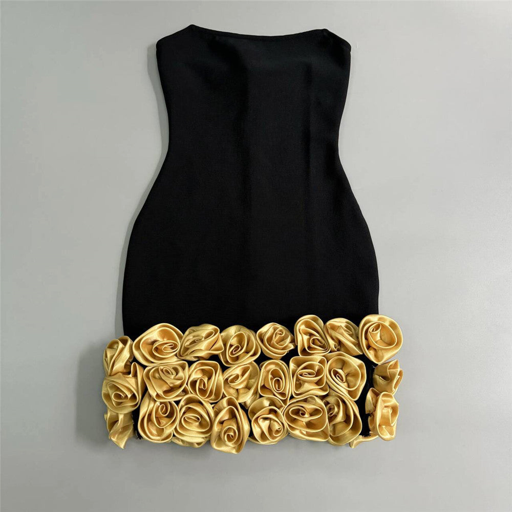 black strapless mini dress with gold rose embellishments at the hem laying flat