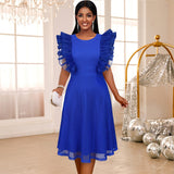 A woman in a royal blue dress with ruffled sleeves and a mesh overlay