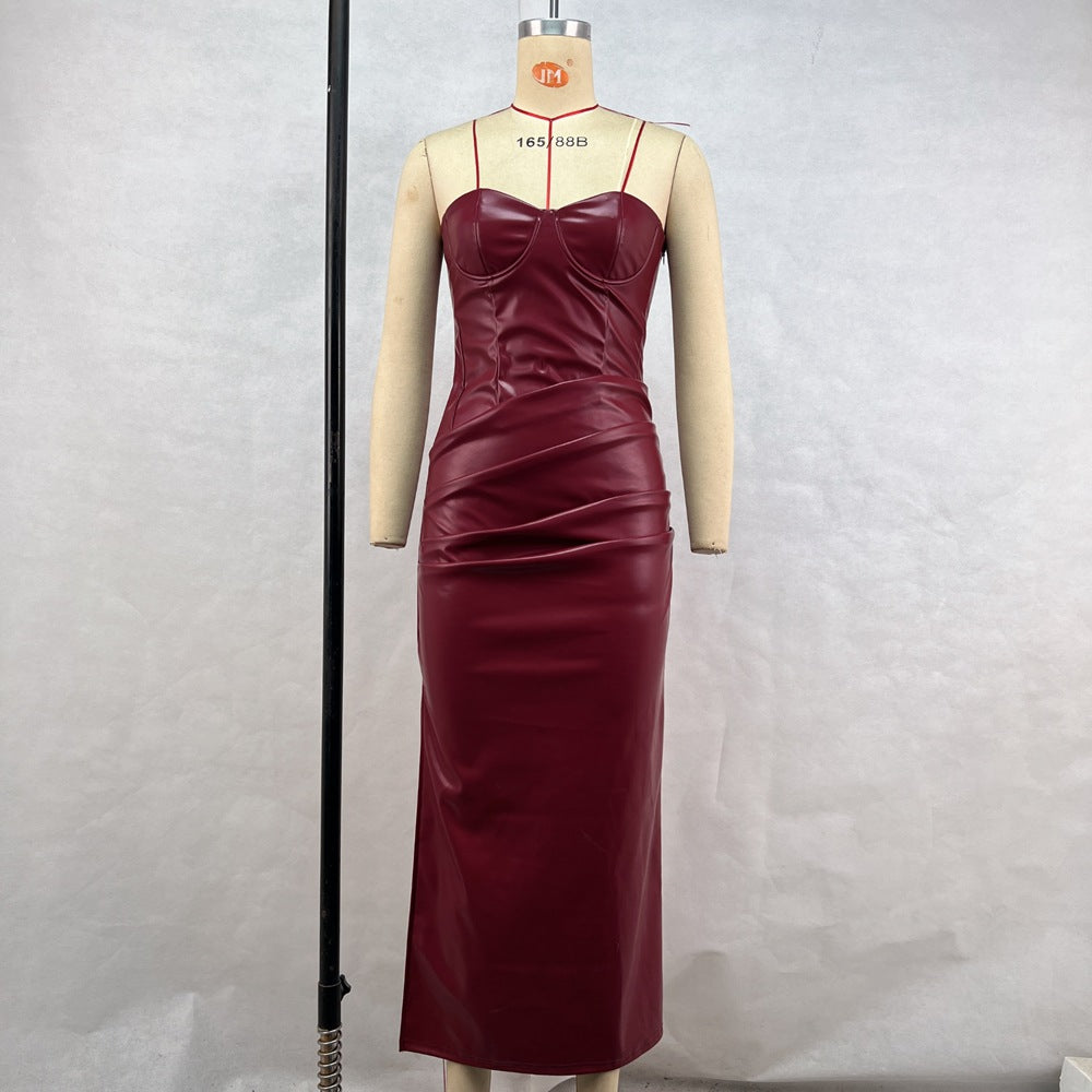 A mannequin displays a burgundy faux leather strapless maxi dress with ruching detail and a thigh-high slit.