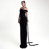 Full-length shot of a model in a black ruched gown with a train, showcasing the off-the-shoulder design and halter neckline.