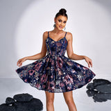 A woman poses in a navy blue floral sequined mini dress with her arms outstretched