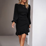 woman wearing a black long-sleeved mini dress with ruffled hem and ruched waist