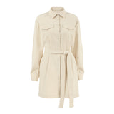 A long-sleeved beige shirt dress with a belted waist and chest pockets, displayed against a white background.