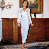 A woman poses in a white satin wrap top and sequined skirt.