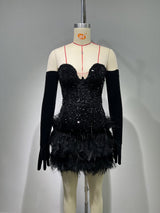 A black sequined and feathered mini dress with long black gloves displayed on a mannequin.