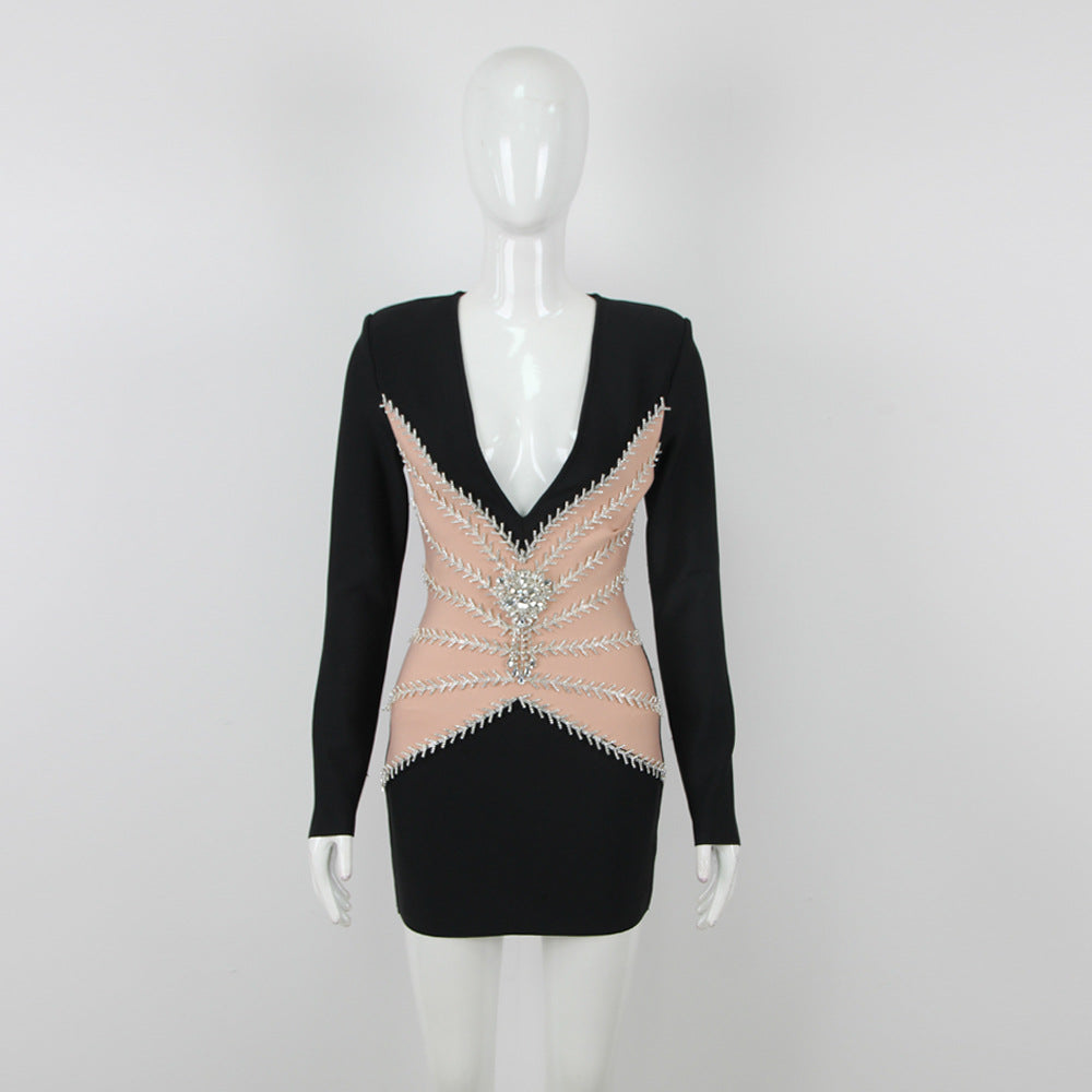 Mannequin displaying a black mini dress with a deep V-neck, sheer paneling, and silver embellishments.