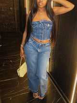A woman wearing a blue denim strapless corset top with matching blue denim pants