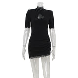 A black mini dress with lace trim, a cutout, and ruching is displayed on a mannequin.