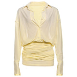 A pale yellow sheer dress with a ruched body and a button-up shirt top.
