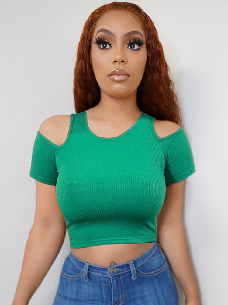 Woman wearing a green cropped ribbed t-shirt with cold shoulder cutouts and blue jeans