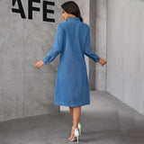 Back view of a woman in a denim dress, walking away.