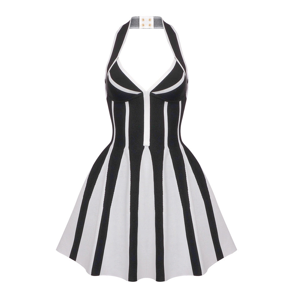 A black and white knit halter neck fit and flare dress with a striped pattern, laid flat.