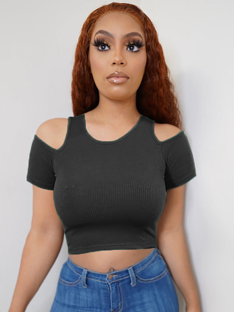 Woman wearing a black cropped ribbed t-shirt with cold shoulder cutouts and blue jeans