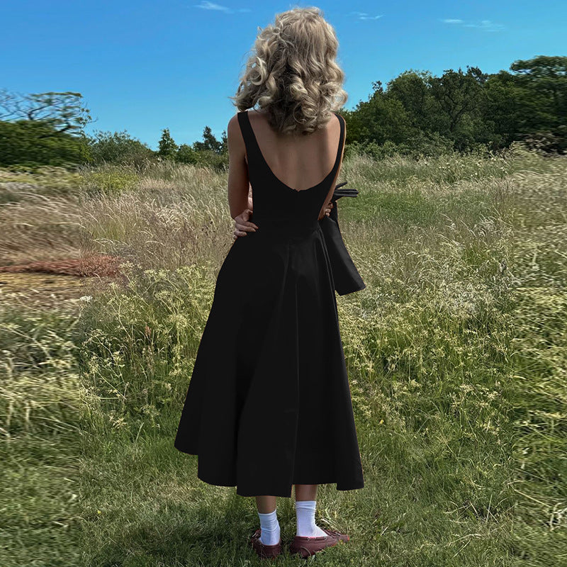 woman in black dress from behind in a field