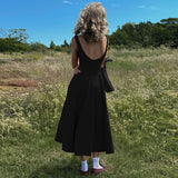 woman in black dress from behind in a field