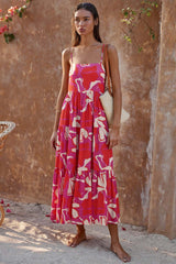 woman wearing a red, pink, and white leaf print tiered midi dress