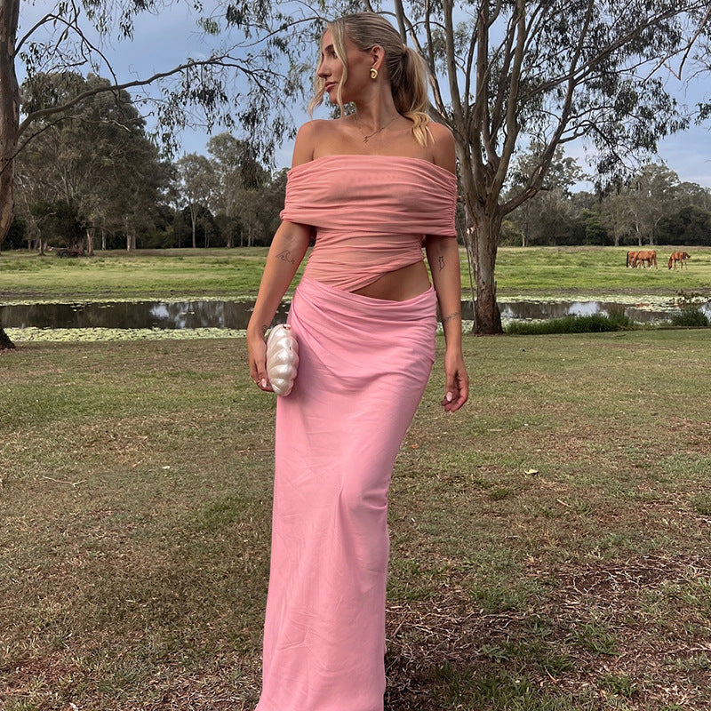 woman in pink off-the-shoulder ruched top and pink skirt holding a clutch