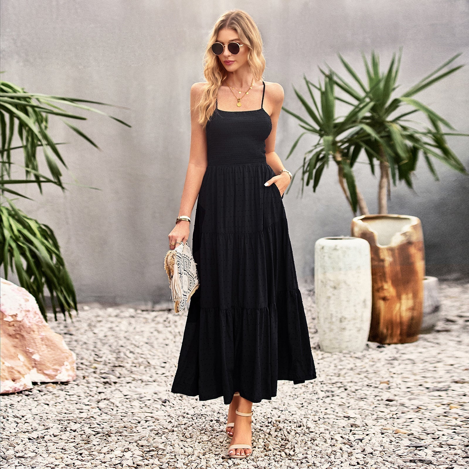Woman wearing a black tiered maxi dress with spaghetti straps and smocked bodice