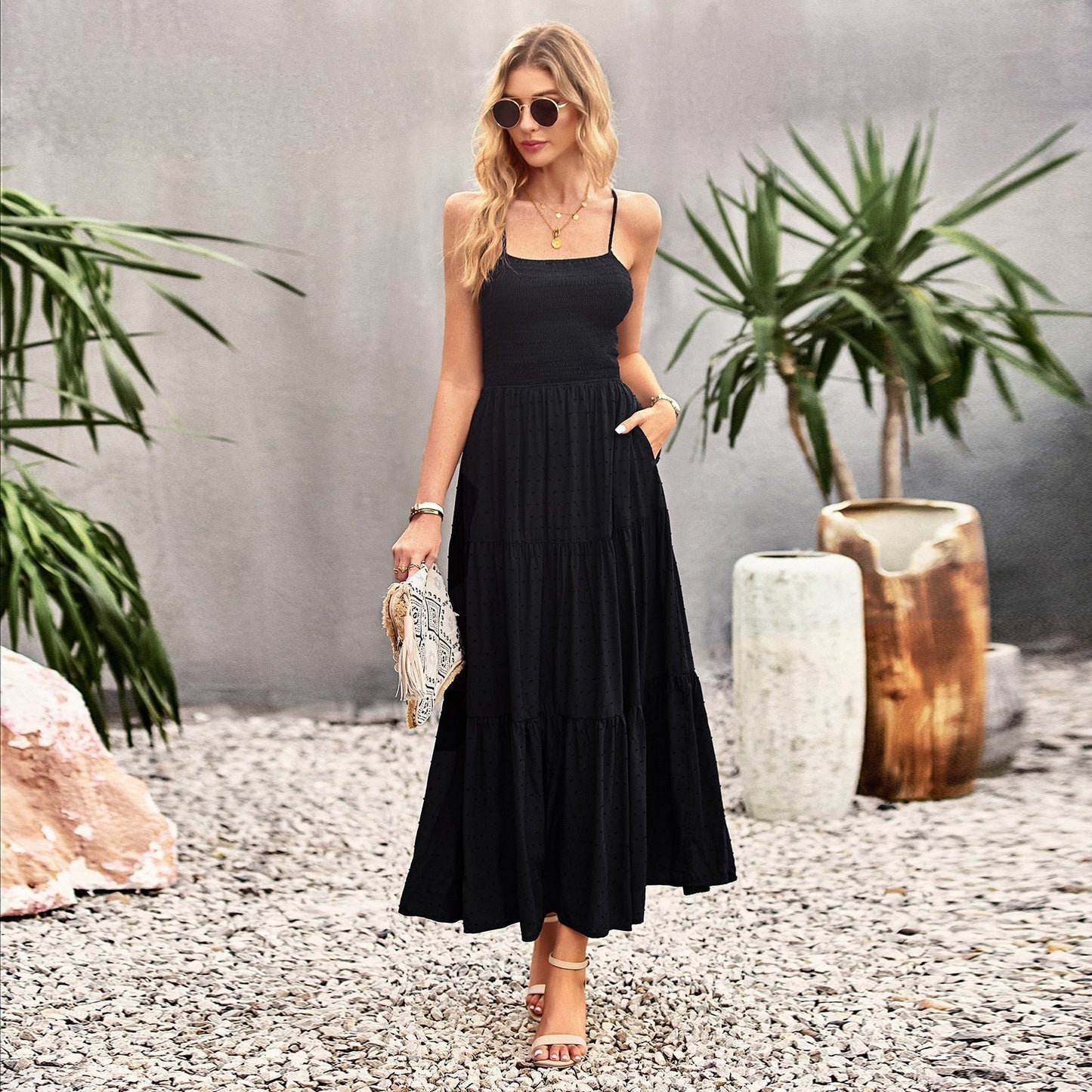 Woman wearing a black tiered maxi dress with spaghetti straps and smocked bodice