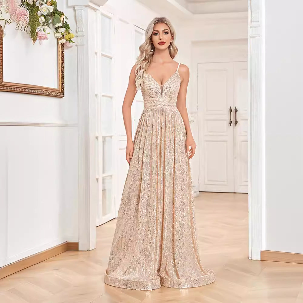 Woman in a gold sequined floor-length dress with spaghetti straps and a v-neck