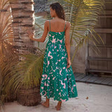 woman wearing a green and pink leaf print tiered midi dress from the back