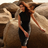 A woman with long, brown hair wears a black mock neck dress with white stripes.