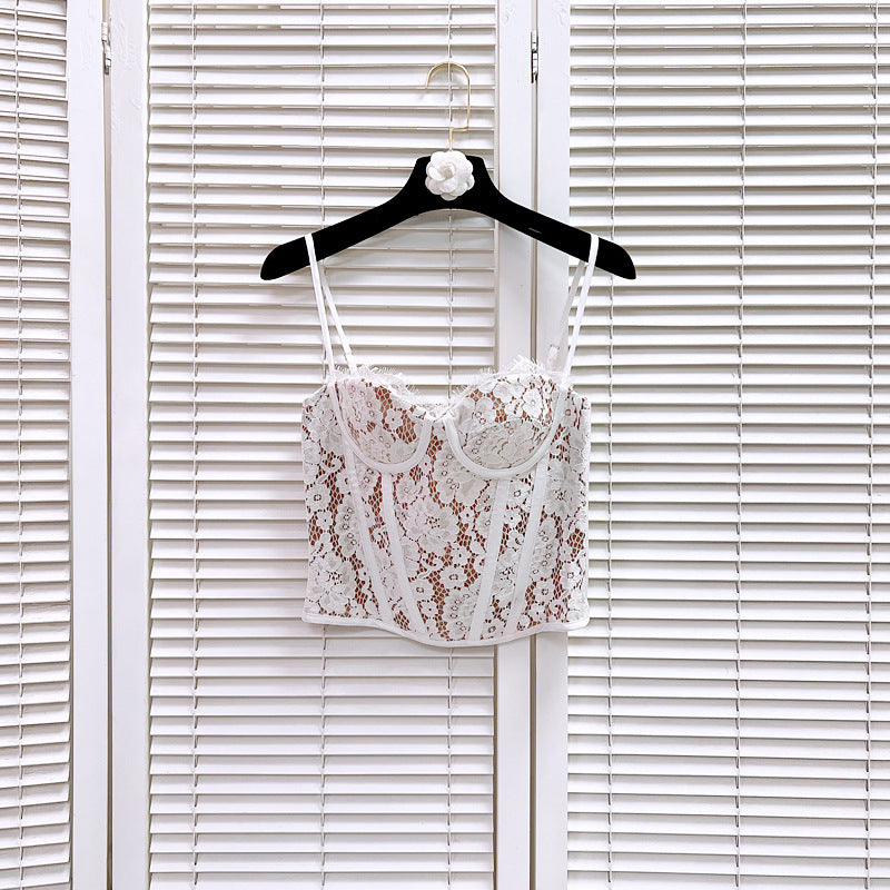 A white lace corset top with tan lining, featuring intricate floral lace and structured boning, hangs on a black hanger.
