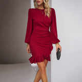 woman wearing a red long-sleeved mini dress with ruffled hem and ruched waist