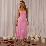 A woman walks in a pink slip dress, with candles and rose petals on the floor.