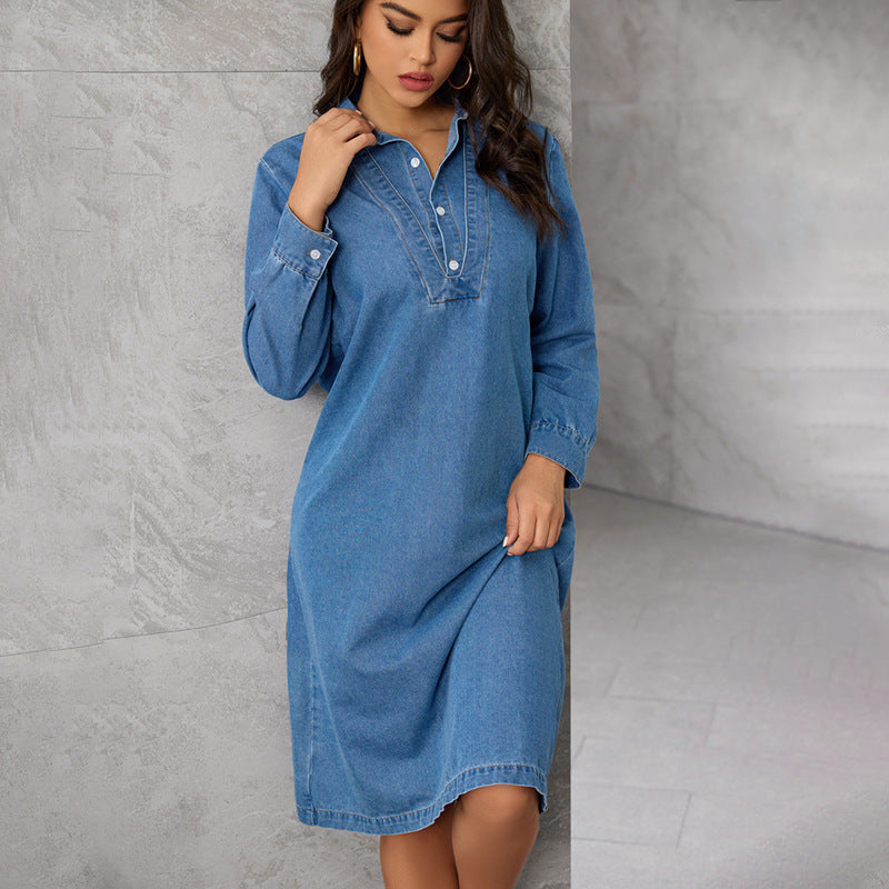 Close-up of a woman in a denim dress, touching her collar.