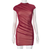 A mannequin wearing a short, form-fitting burgundy dress with sheer fabric and ruching.